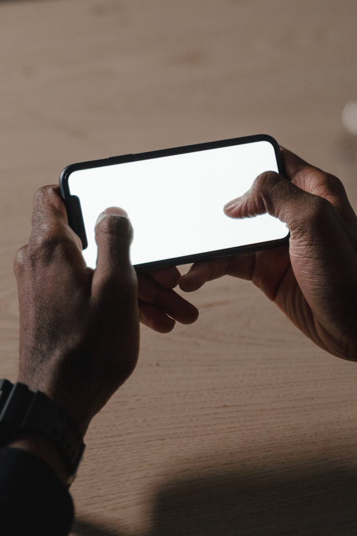 Hands holding a blank smartphone screen, ideal for mockup use. Perfect for technology themes.